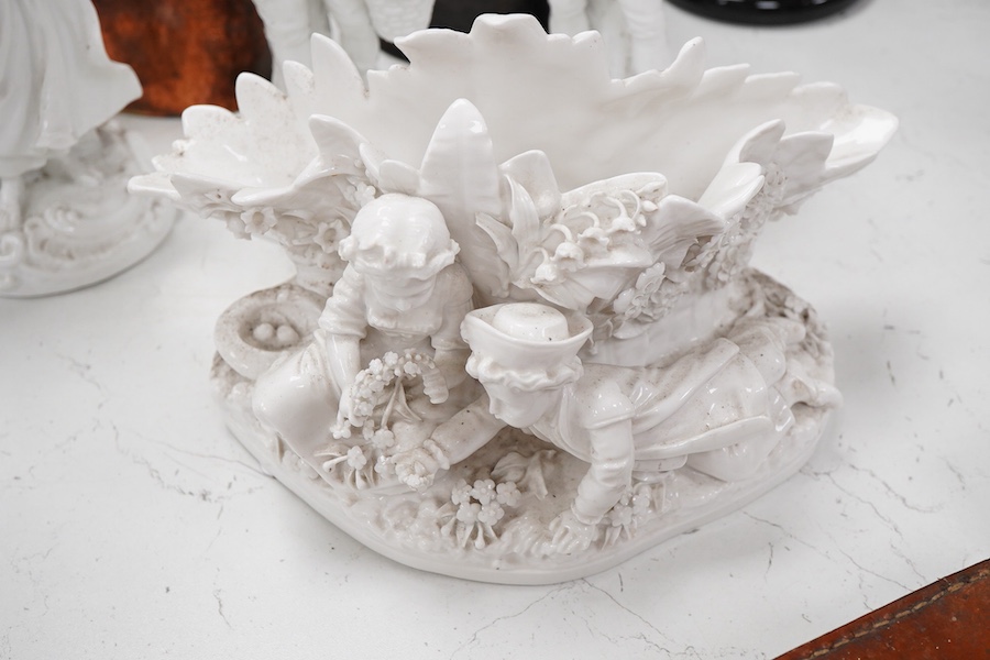 Three Continental white glazed figures and an English bone china group, tallest 25cm